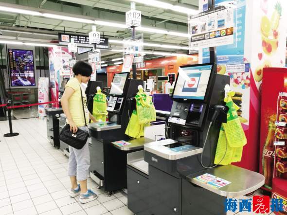 　　消费者使用自助收银台买单。